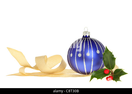 Decorazione di natale di blu ninnolo, nastro color oro e un rametto di agrifoglio con bacche rosse isolata contro bianco Foto Stock