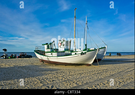 Una lineup di due piccoli danese barche da pesca spiaggiata a Lokken in Jutland settentrionale con dune di sabbia in background Foto Stock