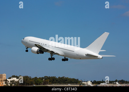 Viaggi aerei. Boeing 767 grande aereo commerciale passeggeri che decollo contro un cielo azzurro. Nessuna livrea e dettagli proprietari sugli aeromobili cancellati Foto Stock