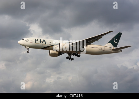 PIA Pakistan International Airlines Boeing 777-200 ER sull approccio contro un cielo nuvoloso Foto Stock