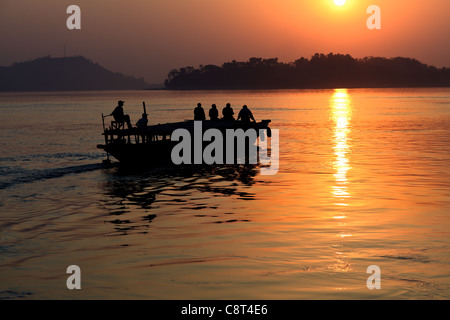 Una barca al tramonto sul fiume Brahmaputra, Assam, India Foto Stock