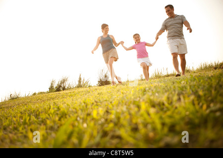 Famiglia tenendo le mani e camminare insieme Foto Stock