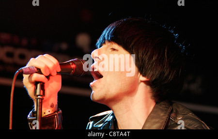 Tim Burgess dell'inglese rock band, i ciarlatani canta ad un in-store gig presso un negozio Zavvi a Londra, in Oxford Street Foto Stock