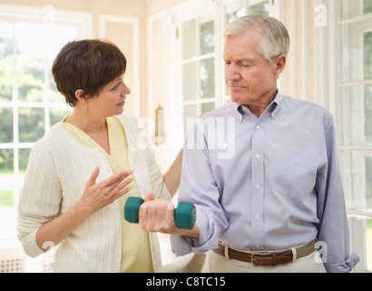 Stati Uniti d'America, nello Stato di New York, Old Westbury, Senior uomo il sollevamento di pesi, infermiere che lo assistono Foto Stock