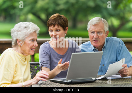 Stati Uniti d'America, nello Stato di New York, Old Westbury, Senior genitori e figlia adulta utilizzando laptop sul portico Foto Stock