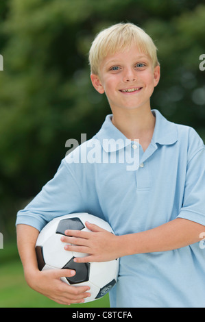 Stati Uniti d'America, nello Stato di New York, Old Westbury, ragazzo tenendo palla calcio Foto Stock