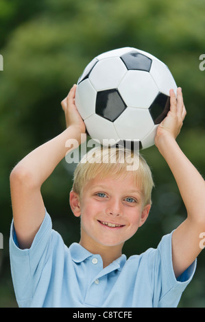 Stati Uniti d'America, nello Stato di New York, Old Westbury, ragazzo tenendo palla calcio Foto Stock