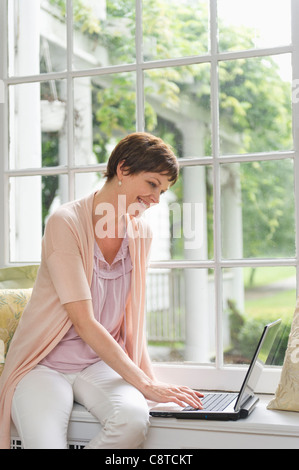 Stati Uniti d'America, nello Stato di New York, Old Westbury, Donna utilizzando portatile a casa Foto Stock