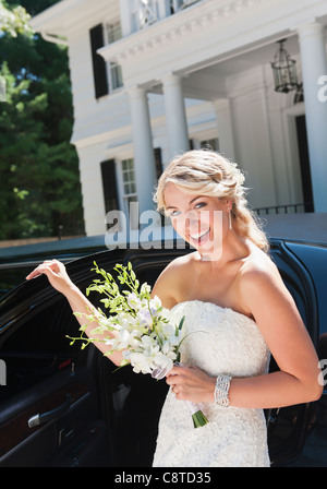 Stati Uniti d'America, nello Stato di New York, Old Westbury, sposa sorridente in piedi vicino limousine Foto Stock