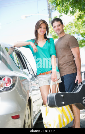 Stati Uniti d'America, New Jersey, Jersey City, sorridente coppia in vacanza in piedi accanto a AUTO Foto Stock