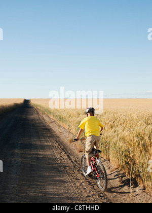 Stati Uniti d'America, Oregon, Wasco, ragazzo escursioni in bicicletta lungo la strada sterrata Foto Stock