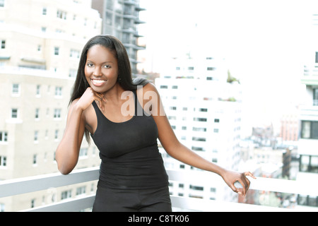 Stati Uniti d'America, New York City, Ritratto di giovane donna sul balcone Foto Stock