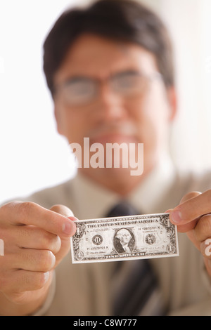 Triste business man tenendo un dollaro nota Foto Stock