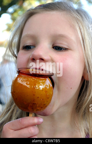 Ragazza di mangiare una caramella mou Apple Foto Stock