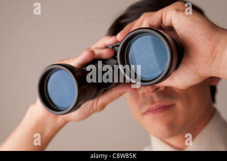 Imprenditore cerca attraverso il binocolo Foto Stock