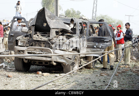 A Peshawar, Pakistan, NOV 02: poliziotti di ispezionare il veicolo danneggiato che era stato distrutto dopo l esplosione di una bomba al sito alla periferia di Peshawar Mercoledì, Novembre 02, 2011. Almeno una persona è stata uccisa e più di sette persone ferite. Foto Stock