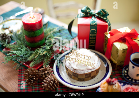 Torta decorativa, confezioni regalo e candela accesa Foto Stock