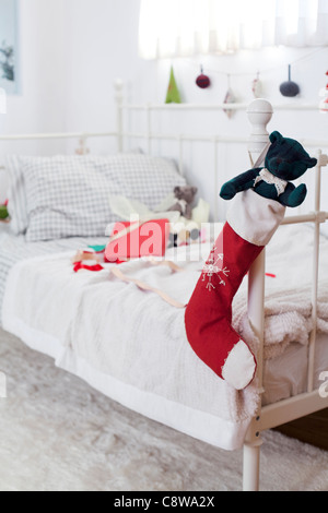 Orsacchiotto di peluche In Calze di Natale appeso alla maniglia del lettino e dono non confezionate Foto Stock