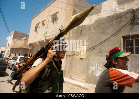 Un ribelle fighter anticipi per estrarre il governo pro sniper posizione come ribelli storm Gheddafi palace Foto Stock