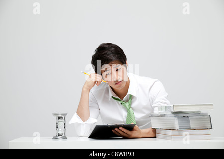 Imprenditore asiatici annoiarsi durante il lavoro Foto Stock