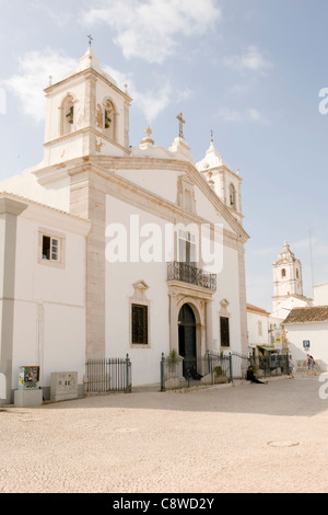 Il Portogallo Algarve Lagos acciottolate Praca Dom Henrique piazza Chiesa di Santa Maria Igreja da Santa Maria mendicante sui passi Foto Stock