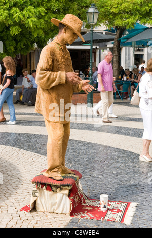 Il Portogallo Algarve Lagos la piazza principale della città vecchia artista mime vestito come fangoso marrone yokel contadini cowboy di accattonaggio open air restaurant cafe al fresco Foto Stock