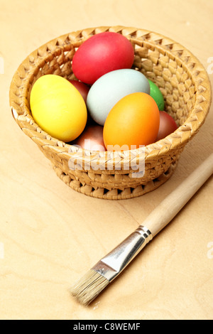 Dipinto di uova di pasqua nel recipiente di paglia e beush Foto Stock