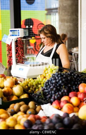 Il Portogallo Algarve Lagos indoor Mercado Mercato Comunale costruito 1924 Frutta sezione fruitier femmina del fornitore in sacchi scale up contatore nero di uva bianca Foto Stock
