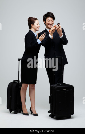 Asian imprenditrice e imprenditore tramite telefono cellulare Foto Stock