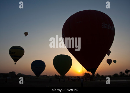 I palloni ad aria calda in decollo all'alba sulle rive del fiume Nilo vicino a Luxor, Egitto Foto Stock