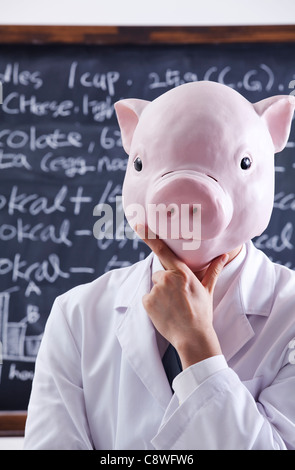 Testa di maiale nutrizionista in piedi di fronte di Blackboard Foto Stock