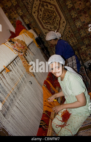 Due signore la tessitura della lana e rendendo i tappeti marocchini in Marrakech Foto Stock