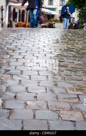 La gente a camminare su una strada acciottolata a Bruges, Belgio Foto Stock