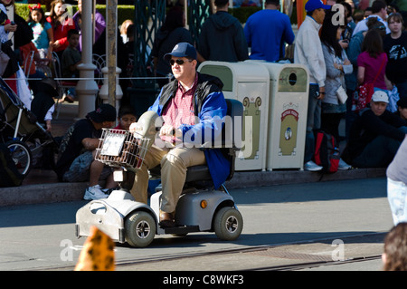 Disabilitato uomo su una mobilità scooter Foto Stock