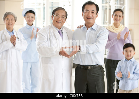 Padre fa a forma di cuore con le mani con i Senior medico Foto Stock