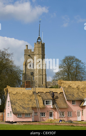 La Thatcher lavorando sul cottage con tetto in paglia tetto in Cavendish, Suffolk REGNO UNITO Foto Stock