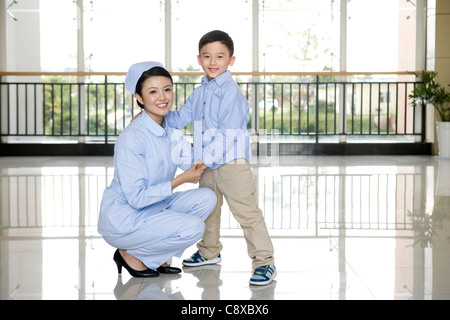 Infermiere e giovane ragazzo in un corridoio di ospedale Foto Stock