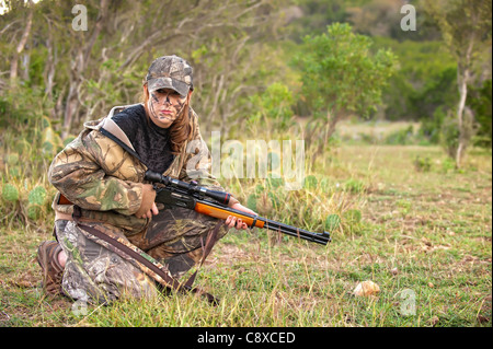 Il cacciatore di sesso femminile in camuffamento vestito con un fucile Foto Stock