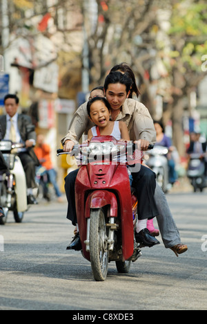 Asia Vietnam Hanoi. Hanoi old quarter. Famiglia vietnamita a cavallo su un piccolo moto attraverso Hanoi.... Foto Stock