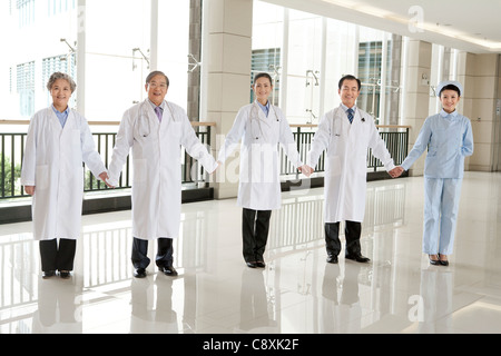 Medici e infermieri mano nella mano Foto Stock