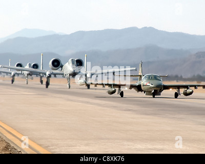 BASE AEREA DI WONJU, Corea del Sud -- UNA forza aerea sudcoreana A-37 conduce due A-10 Thunderbolt IIS dal 25° Squadrone dei combattente alla base aerea di Osan, Corea del Sud, giù la via di taxi qui. I piloti del 25° FS, insieme a 10 manutentori e a un team di forze di sicurezza composto da cinque persone, hanno partecipato a un esercizio incentrato sul controllo in avanti-aereo e sul coordinamento del comando e del controllo delle forze multinazionali. Foto Stock