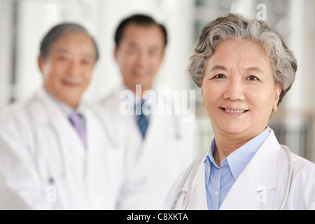 Femmina Senior medico con due medici in background Foto Stock