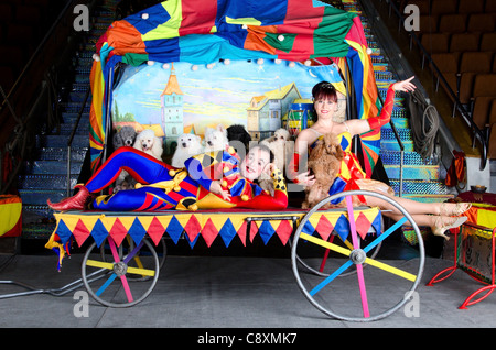 Paio di clown sorridente in posa con i cani di piccola taglia su vintage carrello con la pittura della città vecchia Foto Stock