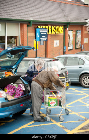 Un paio di caricamento la loro auto con lo shopping al Morrisons store, Bangor Wales UK Foto Stock