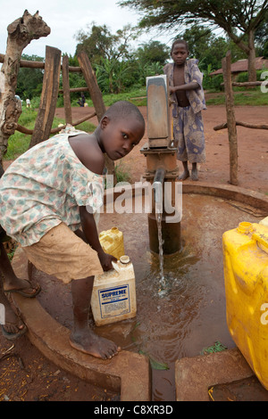 Bambini prendere l'acqua da un pozzo di trivellazione nell est dell Uganda Namutumba distretto. ActionAid - Uganda. Ottobre, 2011. Foto Stock