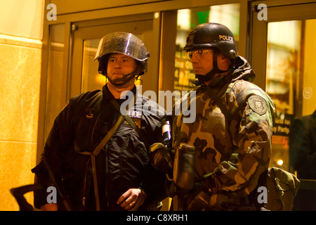 Seattle funzionari di polizia di guardia come voce di occupare i manifestanti di Seattle dimostrano al Sheraton Hotel, Seattle, Washington dove JP Morgan Chase CEO Jamie Dimon sta parlando alla Washington University di Foster School of Business Event Foto Stock