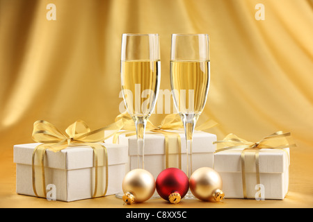 Bicchieri di champagne con confezioni regalo e palle di Natale. Foto Stock