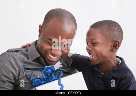 Figlio (6-7) dando presente a suo padre, studio shot Foto Stock