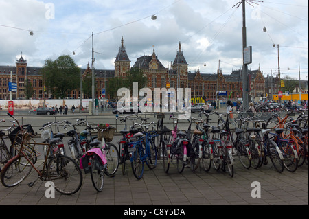 La Stazione Centrale di Amsterdam con decine di cicli parcheggiata in primo piano Foto Stock