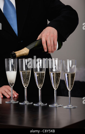 L'uomo versando champagne in bicchieri Foto Stock